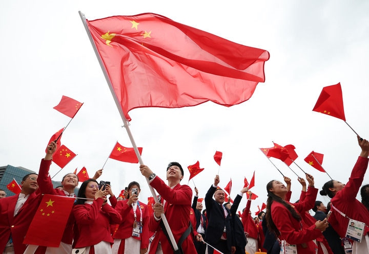 2024年7月26日，在法國(guó)巴黎舉行的第33屆夏季奧林匹克運(yùn)動(dòng)會(huì)開(kāi)幕式正式開(kāi)始前，中國(guó)體育代表團(tuán)旗手揮舞國(guó)旗。新華社記者 曹燦 攝