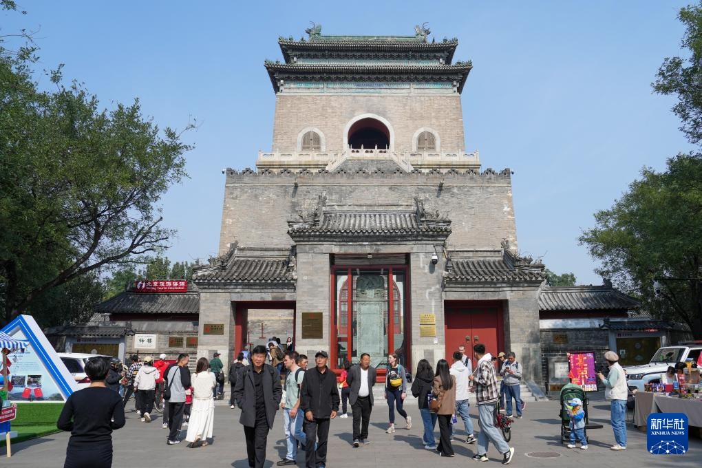 國(guó)慶假期，中外游客在北京鐘樓前參觀游覽。新華社記者 鞠煥宗攝