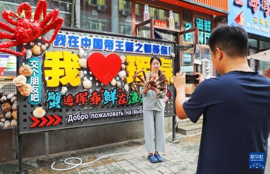 9月21日，游客在吉林省琿春市一處帝王蟹元素主題裝飾前拍照留念。新華社發(fā)