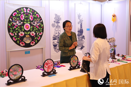 青海非遺文化傳承人向嘉賓介紹展品。人民網(wǎng)實習生姚欣可攝