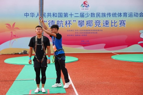 11月23日，工作人員為上海隊(duì)選手付樂樂（左）系安全繩。新華社記者 楊植森 攝
