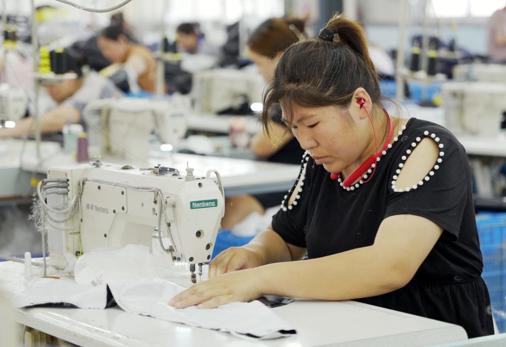 5月20日，村民在李寨村服裝加工廠內(nèi)忙碌。河南省周口市沈丘縣馮營鎮(zhèn)李寨村地處豫東平原。近年來，乘著脫貧攻堅(jiān)與鄉(xiāng)村振興政策的東風(fēng)，李寨村積極探索產(chǎn)業(yè)發(fā)展模式，通過“龍頭企業(yè)+村集體經(jīng)濟(jì)+農(nóng)戶”的方式，逐漸發(fā)展形成肉牛養(yǎng)殖、設(shè)施農(nóng)業(yè)、服裝加工、康養(yǎng)民宿等產(chǎn)業(yè)，以產(chǎn)業(yè)振興助力鄉(xiāng)村振興。新華社記者 李嘉南 攝
