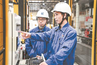 在廣西柳工機(jī)械股份有限公司生產(chǎn)車間內(nèi)，一名高級(jí)技師（右）給徒弟講解數(shù)控設(shè)備操作細(xì)節(jié)。新華社記者 曹祎銘攝