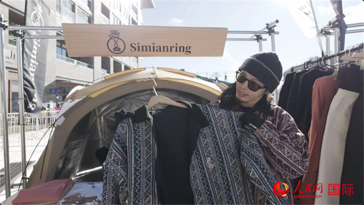 藤田周正在展示自己設(shè)計(jì)的滑雪服。人民網(wǎng)記者 袁蒙攝