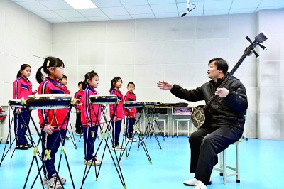 圖為12月30日，在惠民縣胡集鎮(zhèn)第一小學(xué)，老師指導(dǎo)學(xué)生學(xué)習(xí)西河大鼓。新華社記者 郭緒雷攝