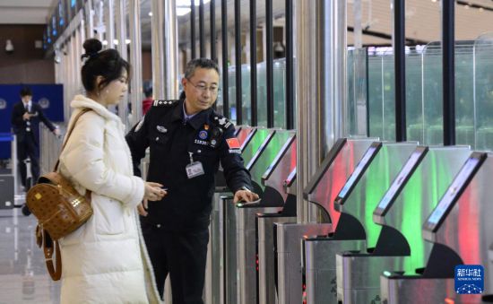 1月2日，大興機場邊檢站警察指導旅客使用自助出境設備。新華社記者 李欣 攝