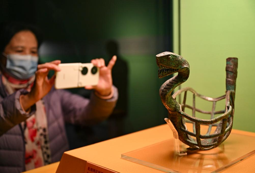 1月14日，觀眾在上海博物館蛇年迎春展拍攝展品蛇綱網(wǎng)狀銅器。新華社發(fā)（陳浩明攝）