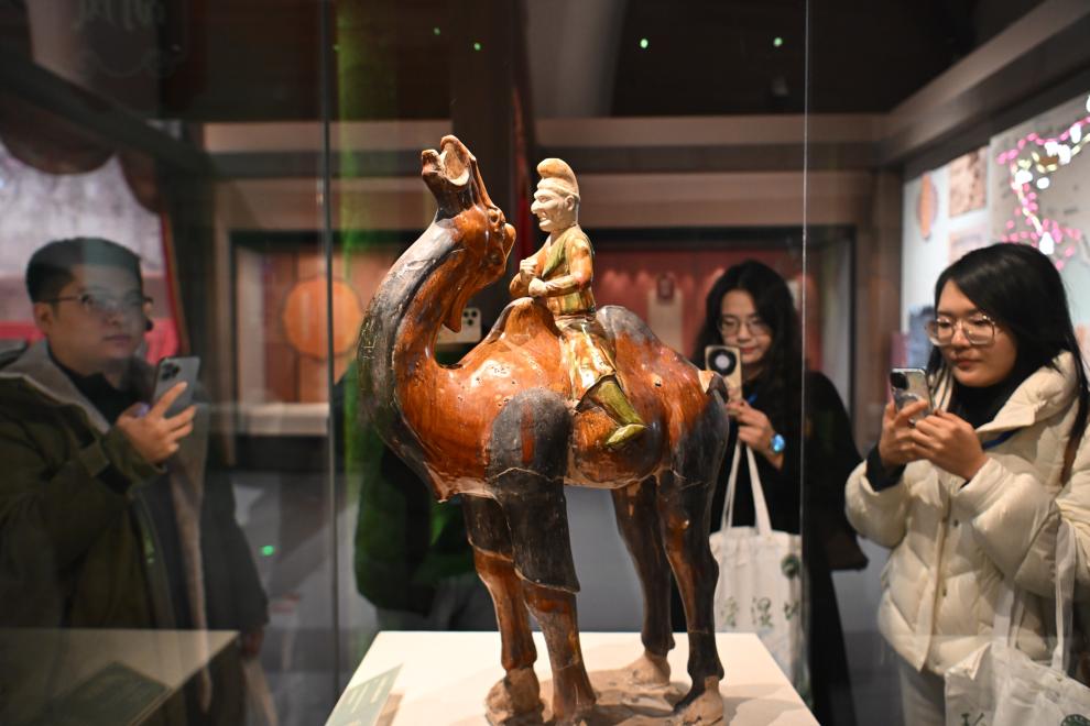 1月15日，觀眾在拍攝“長(zhǎng)安三萬(wàn)里——陜西唐代文物精華展”展出的三彩胡人騎駝俑。（新華社記者 孫凡越 攝）