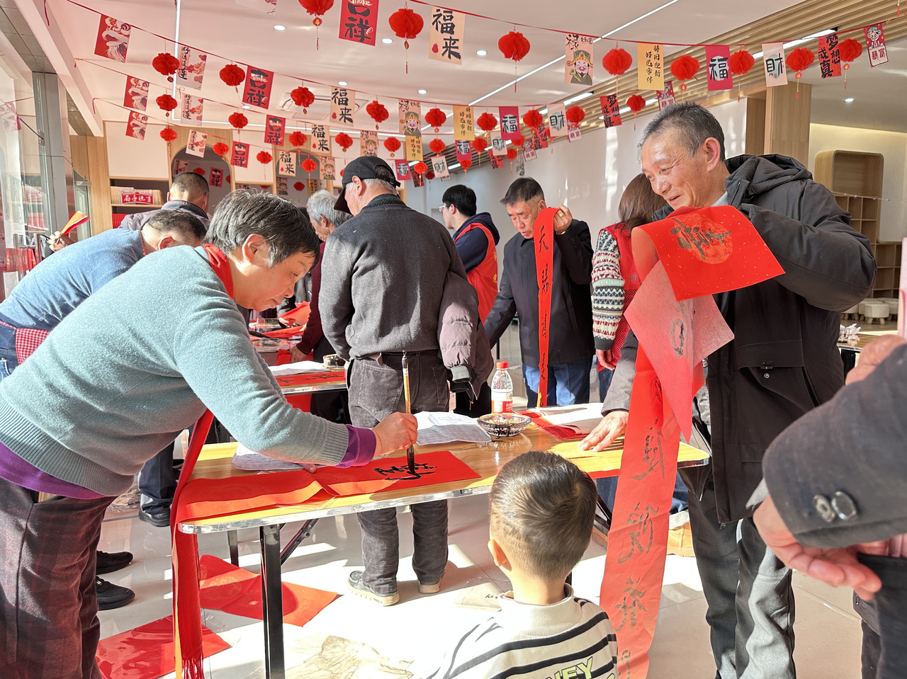 今年春節(jié)前夕，慶元縣濛洲街道同濟(jì)新村，一場送春聯(lián)活動熱鬧舉行。慶元縣融媒體中心 供圖