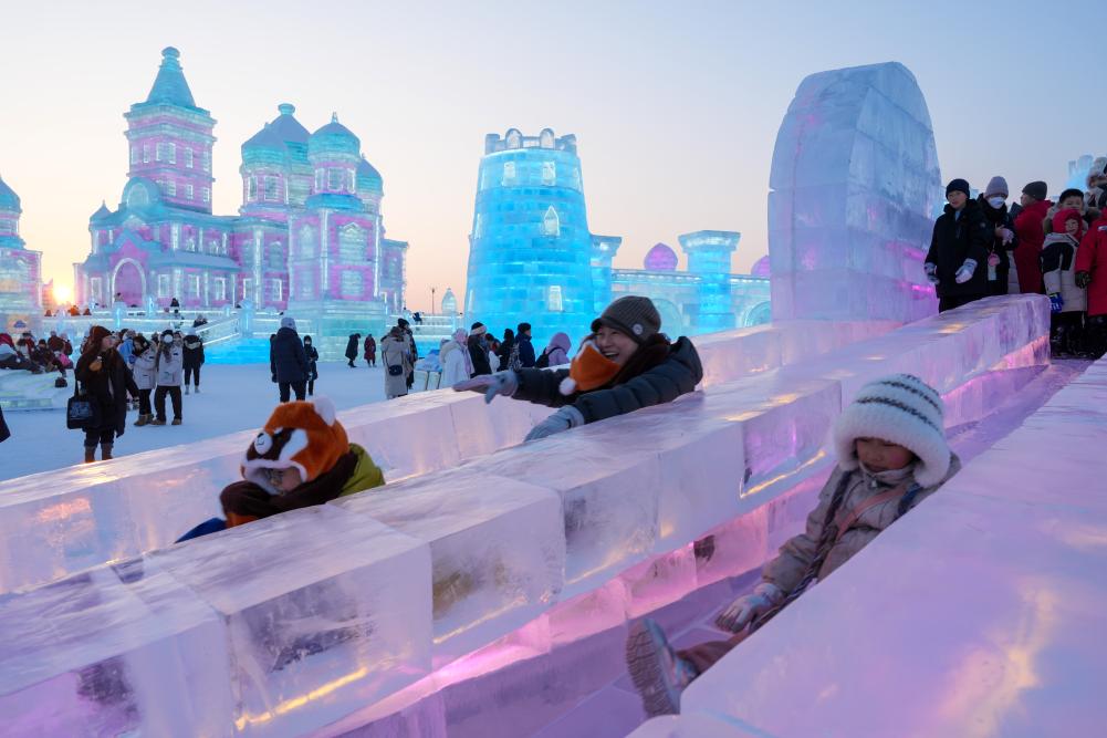 游客在哈爾濱冰雪大世界園區(qū)內(nèi)體驗冰滑梯。新華社發(fā)