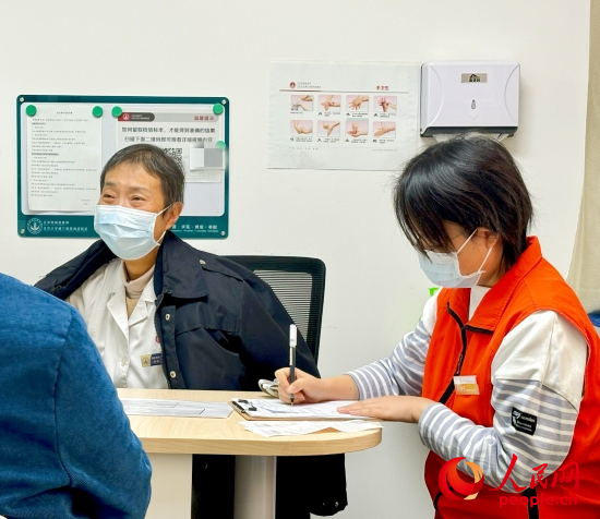 秦苑（中）接診患者。人民網(wǎng)記者 金慧慧攝
