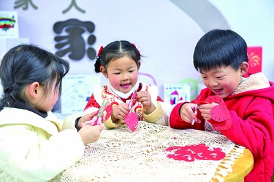 圖為孩子們?cè)诶蠋熤笇?dǎo)下制作蛇年主題剪紙。 新華社記者 徐昱攝