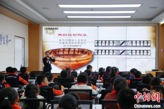 圖為學(xué)生在“國寶音樂會(huì)”社教課中了解舞蹈紋彩陶盆。中新社記者 馬銘言 攝