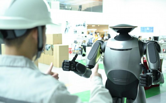 在廣汽研究院，人形機器人團隊的周仁義在演示GoMate機器人互動功能（新華社記者 鄧華 攝）