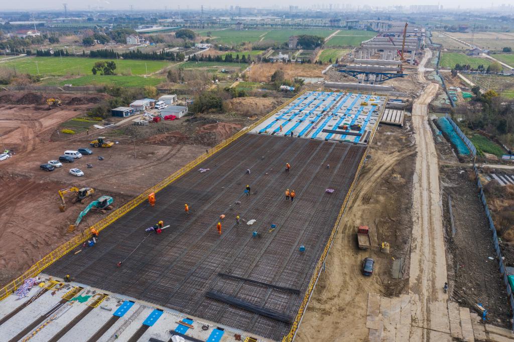 3月7日，在524國(guó)道秀洲王江涇至新塍公路工程TJ02標(biāo)段，作業(yè)人員正在進(jìn)行60米鋼混組合梁現(xiàn)澆橋面板鋼筋焊接及綁扎作業(yè)（無(wú)人機(jī)照片）。新華社記者 徐昱 攝