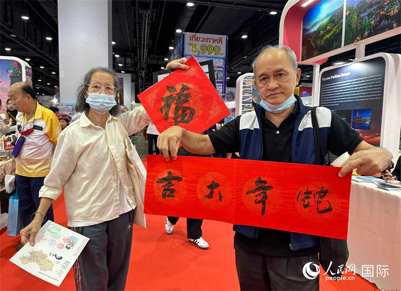 2025蛇年春節(jié)，泰國(guó)市民展示他們領(lǐng)到的華人手寫(xiě)春聯(lián)。人民網(wǎng)記者 簡(jiǎn)承淵攝