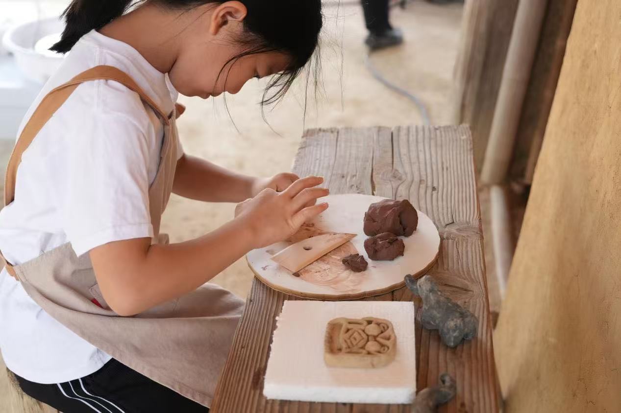 游客制作良渚特色陶藝品。良渚博物院供圖