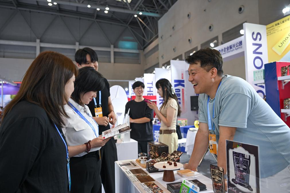 5月22日，韓國展商（右一）在西洽會現(xiàn)場向參觀者介紹產(chǎn)品。新華社記者 陳誠 攝