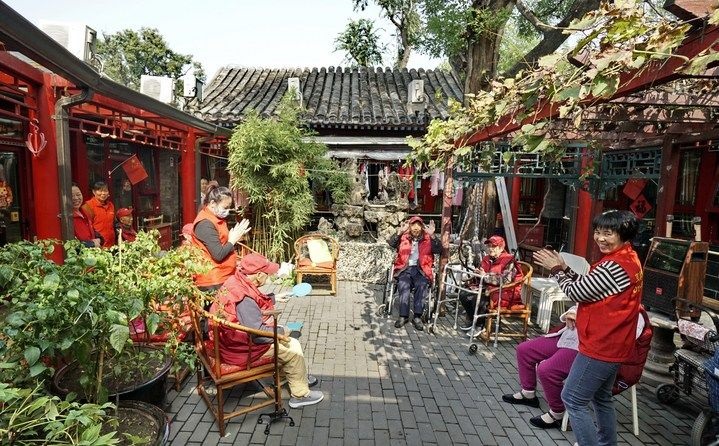 2024年10月12日，鐘樓灣胡同的老年人在社區(qū)內(nèi)的四合院養(yǎng)老驛站休閑。2017年起，北京市先后開展了兩輪背街小巷環(huán)境整治提升行動(dòng)，完整保留了中軸線生活建筑群的歷史信息，并根據(jù)居民的生活和居住方式進(jìn)行適配化的更新和改造，極大地改善了生活環(huán)境。2023年鐘樓灣胡同被評為“北京最美街巷”。