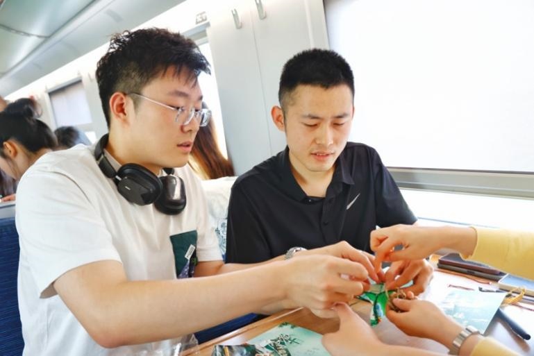 G232次旅客親手制作端午荷包和五彩繩。王磊攝