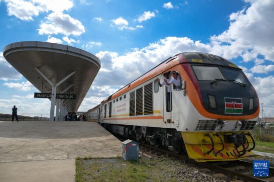 5月31日，在蒙內(nèi)鐵路內(nèi)羅畢站，機(jī)車駕駛員蔣立平（右）和博爾在即將開往蒙巴薩的E2次列車上揮手致意。新華社記者 楊光 攝